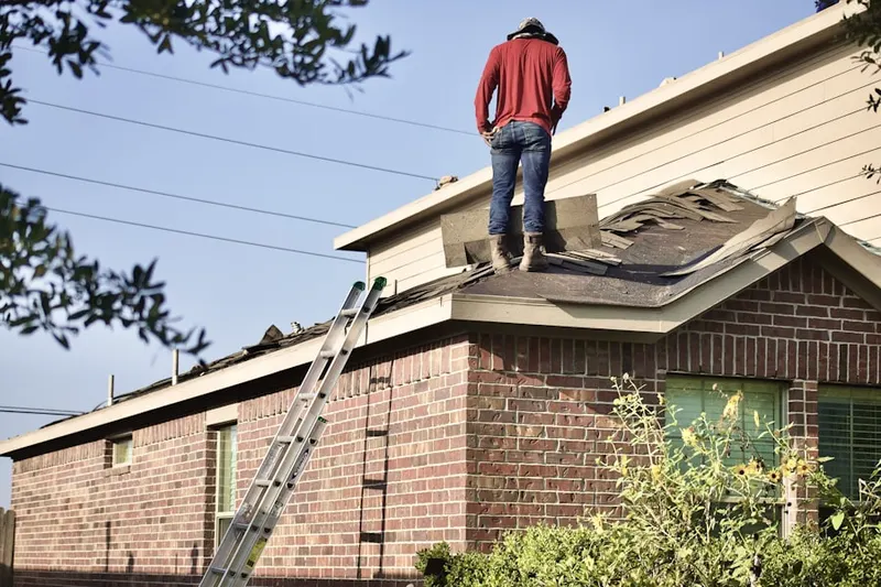 Professional roofer working on a residential roof in Freeland